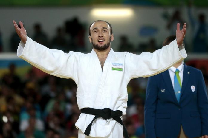 Sherzod Namozov, a male Para judo athlete, opens his arms
